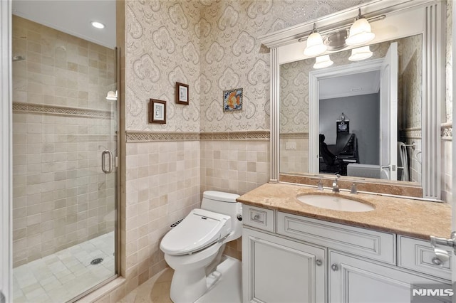 bathroom featuring tile patterned flooring, vanity, tile walls, toilet, and a shower with shower door