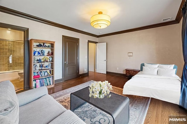 bedroom with ensuite bathroom, dark hardwood / wood-style floors, and crown molding