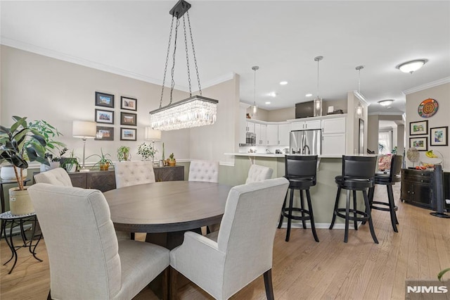 dining room featuring light hardwood / wood-style floors and crown molding