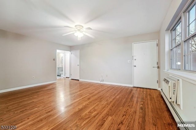 unfurnished room featuring wood-type flooring, a baseboard radiator, and ceiling fan