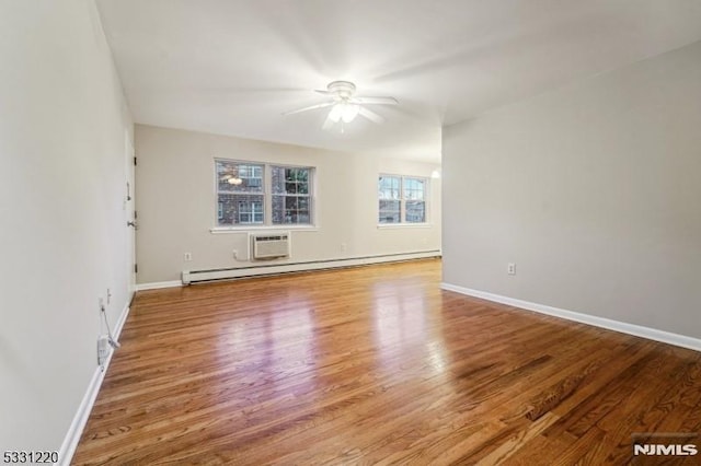 unfurnished room featuring ceiling fan, light wood-type flooring, a wall mounted air conditioner, and a baseboard heating unit