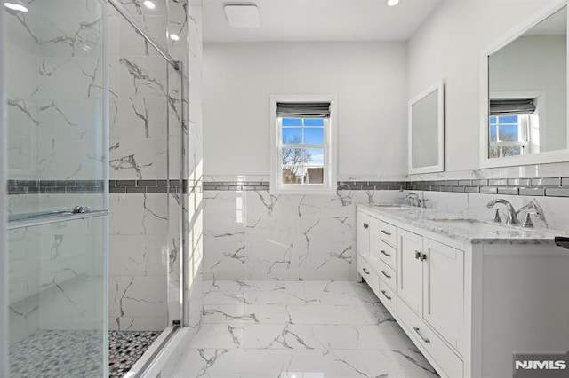 bathroom featuring tile walls, a shower with door, and vanity