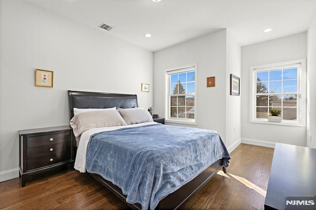 bedroom featuring dark wood-type flooring and multiple windows