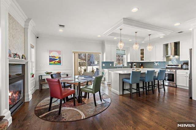 dining room with crown molding and dark hardwood / wood-style floors