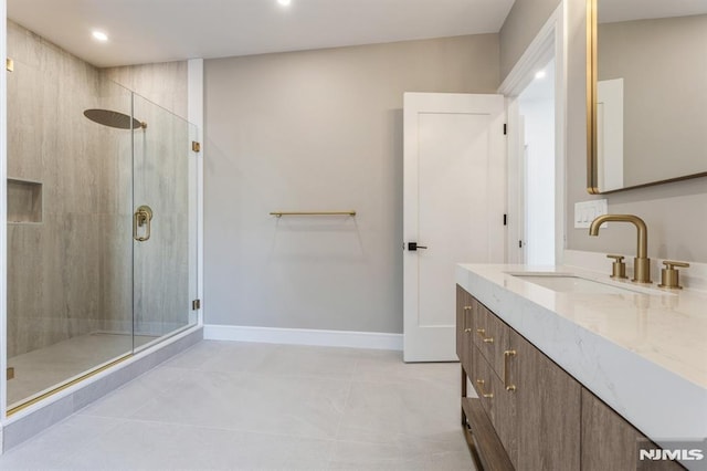 bathroom with tile patterned floors, a shower with shower door, and vanity