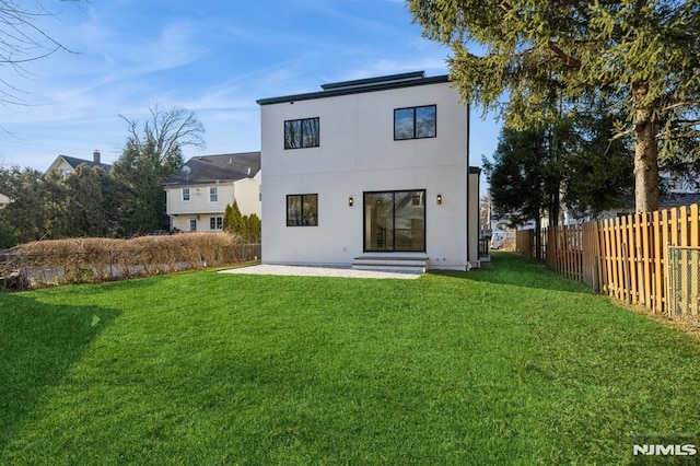 rear view of house with a yard and a patio