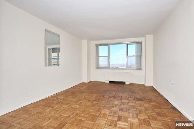 empty room with radiator and light parquet floors