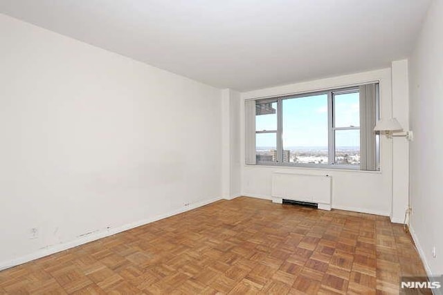 empty room with parquet floors and radiator