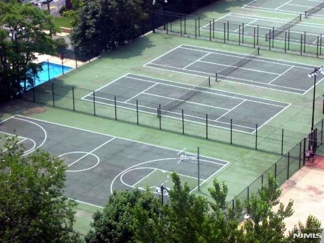 exterior space with basketball court and a fenced in pool