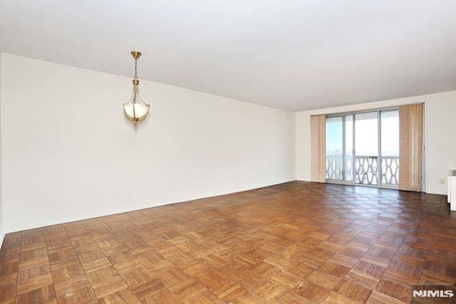 unfurnished room with radiator heating unit and dark parquet floors