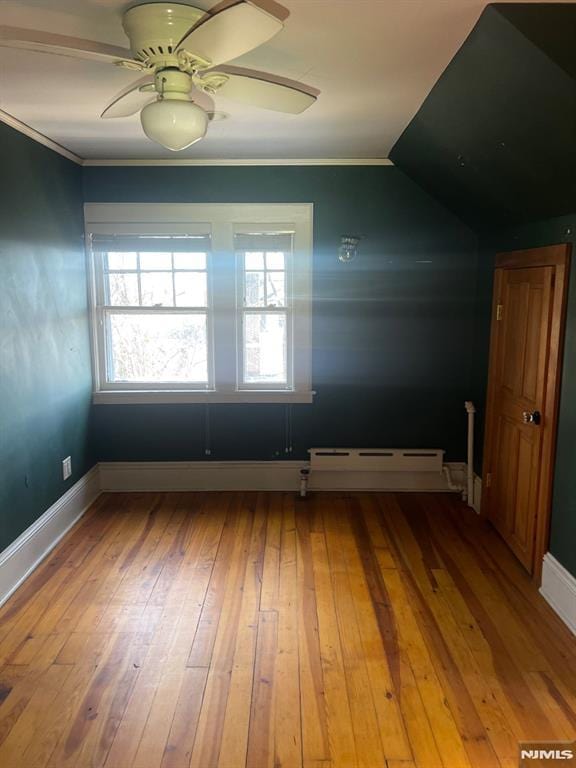 spare room featuring ceiling fan, hardwood / wood-style floors, vaulted ceiling, and a baseboard radiator