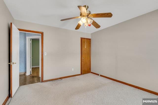 carpeted empty room featuring ceiling fan