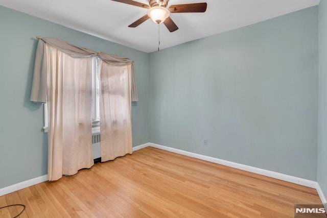 spare room with ceiling fan and light hardwood / wood-style flooring