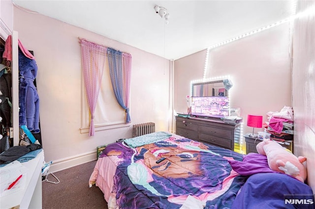 bedroom featuring radiator and dark carpet