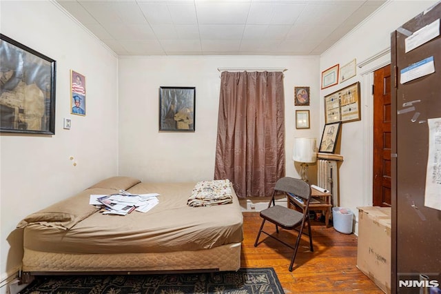 bedroom featuring hardwood / wood-style flooring and crown molding