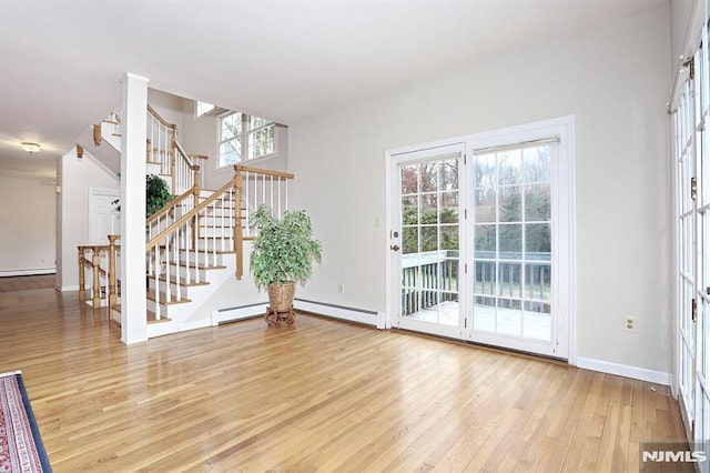 interior space featuring baseboard heating and light hardwood / wood-style floors