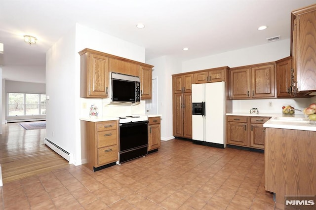 kitchen featuring range with electric stovetop, sink, white refrigerator with ice dispenser, and a baseboard radiator