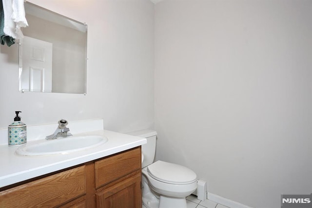 bathroom featuring toilet, vanity, and tile patterned flooring