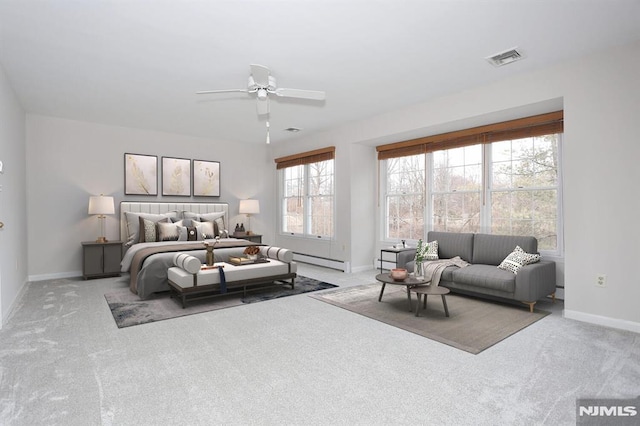 carpeted bedroom with ceiling fan and baseboard heating