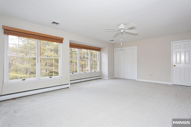 unfurnished living room featuring ceiling fan, baseboard heating, and light carpet