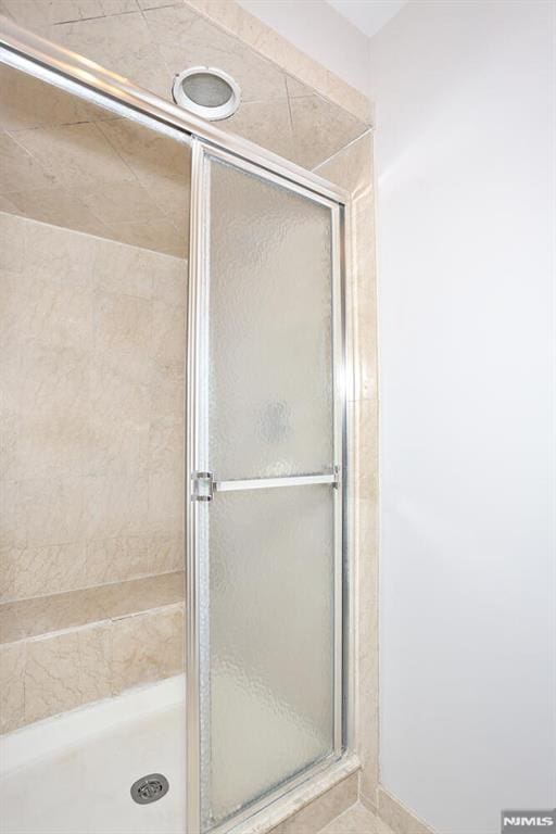 bathroom featuring a shower with shower door