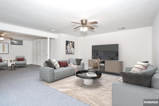 living room with ceiling fan and carpet