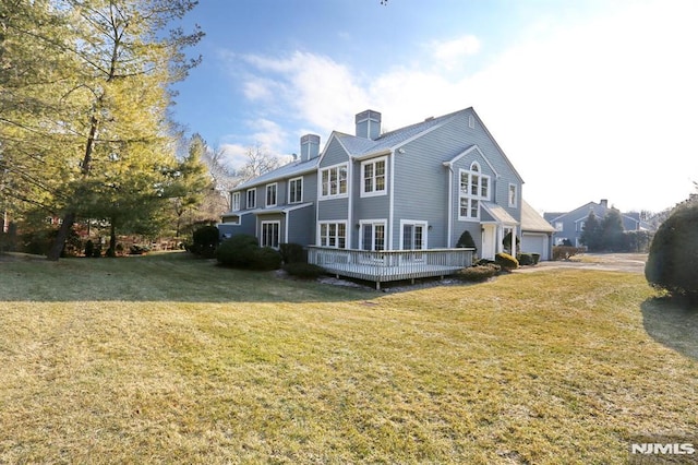 exterior space with a lawn, a deck, and a garage