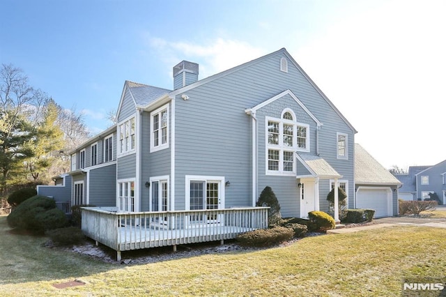 view of front of property featuring a wooden deck, a front yard, and a garage