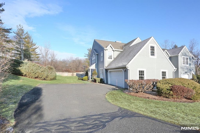 view of side of home with a lawn and a garage