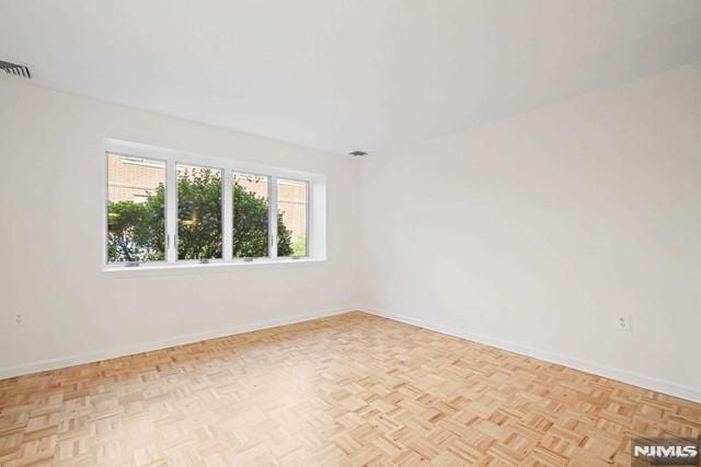 unfurnished room with light parquet flooring