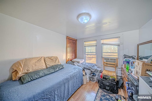 bedroom with cooling unit and hardwood / wood-style flooring