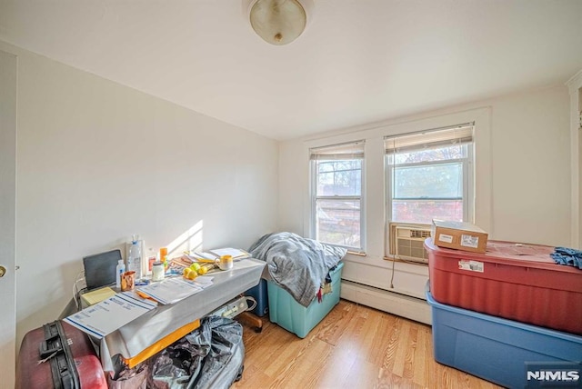 office space featuring light wood-type flooring, cooling unit, and a baseboard radiator