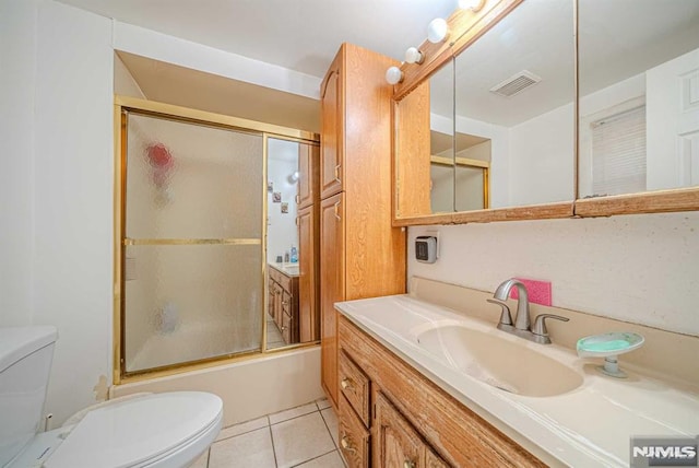 full bathroom featuring toilet, tile patterned flooring, enclosed tub / shower combo, and vanity