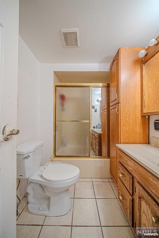 full bathroom featuring enclosed tub / shower combo, tile patterned flooring, vanity, and toilet