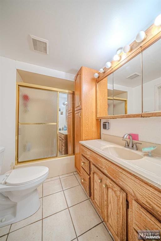 full bathroom featuring shower / bath combination with glass door, toilet, tile patterned floors, and vanity