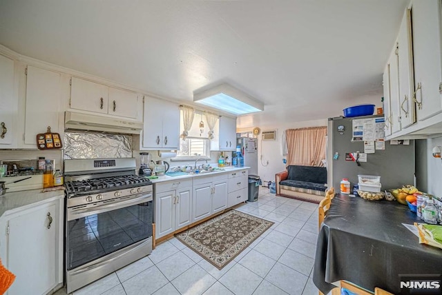 kitchen with light tile patterned floors, backsplash, white cabinets, appliances with stainless steel finishes, and sink