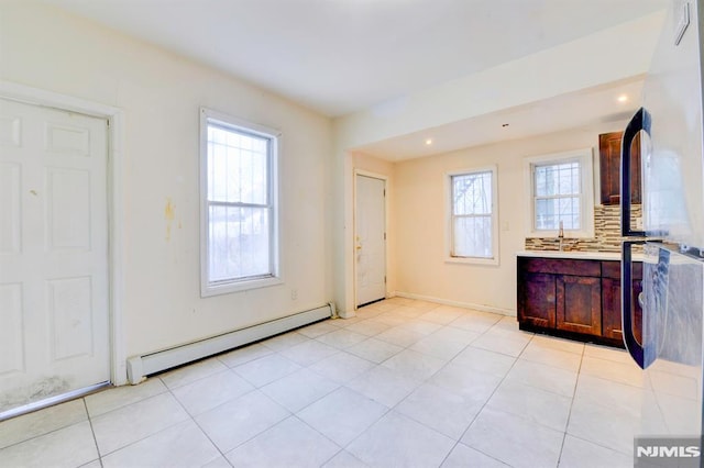 interior space featuring backsplash, tile patterned floors, vanity, and a baseboard radiator