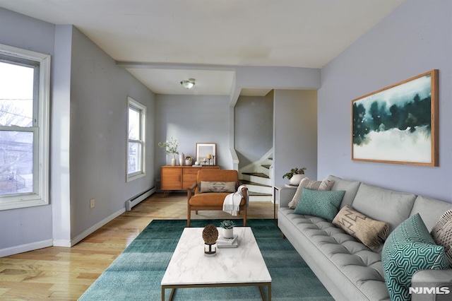 living room with light wood-type flooring and a baseboard heating unit