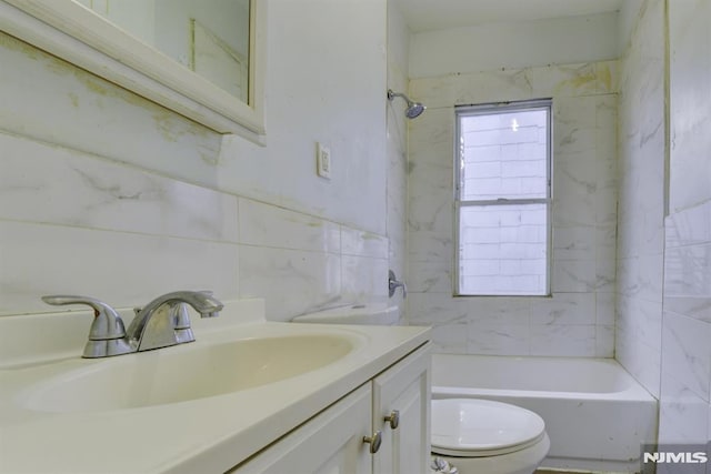 full bathroom featuring vanity, toilet, and tiled shower / bath