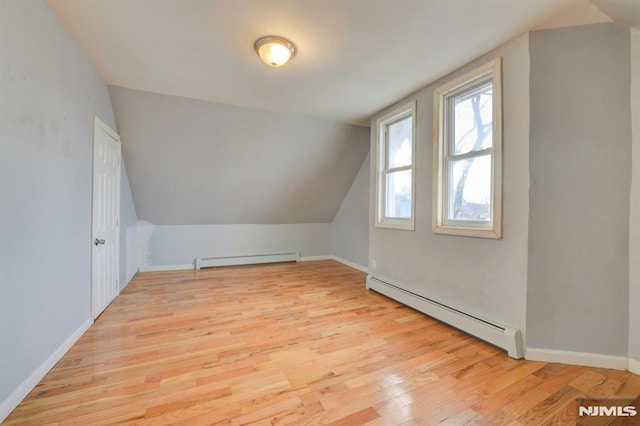 bonus room with light hardwood / wood-style flooring, baseboard heating, and lofted ceiling