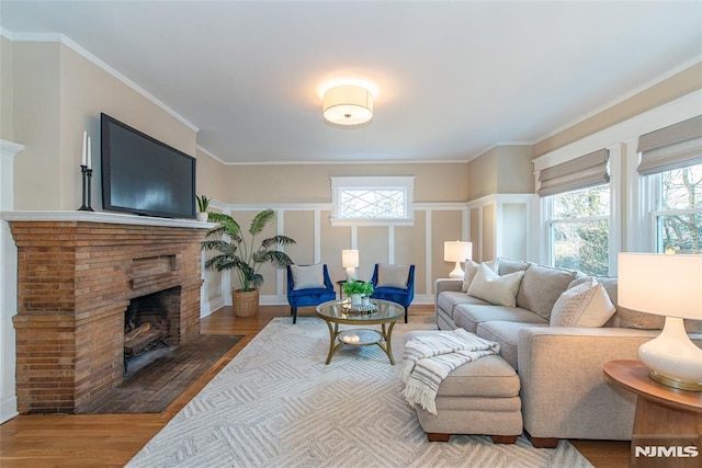 living room with a fireplace, wood-type flooring, and crown molding