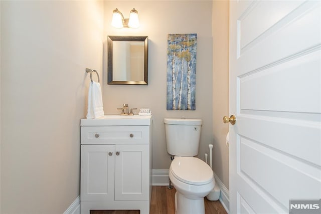 bathroom featuring vanity, hardwood / wood-style flooring, and toilet