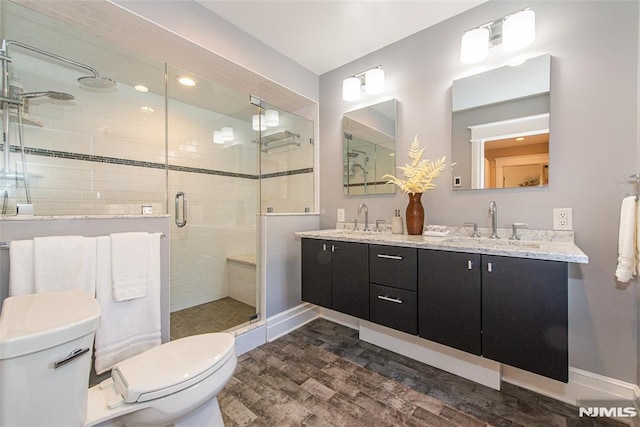 bathroom with vanity, wood-type flooring, a shower with shower door, and toilet