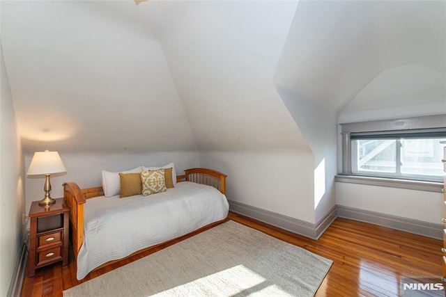 bedroom featuring hardwood / wood-style floors and lofted ceiling