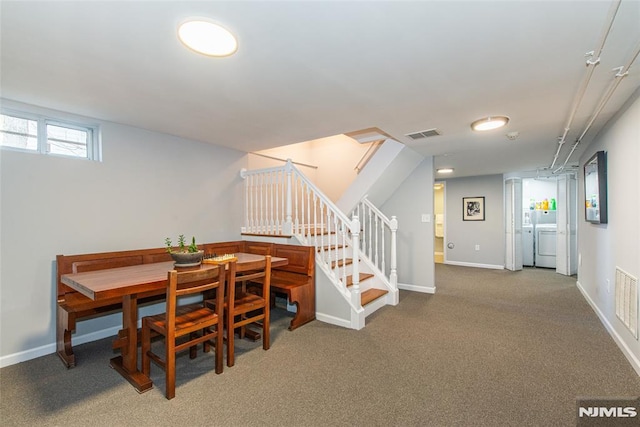 carpeted dining area featuring washer and clothes dryer