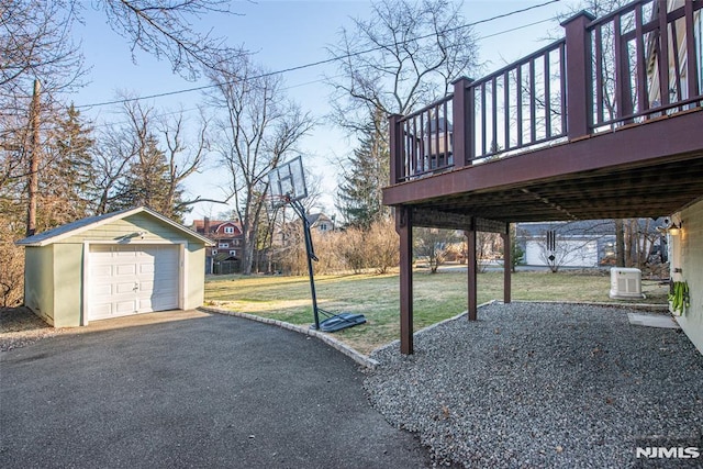 view of yard featuring a garage, an outdoor structure, and a wooden deck