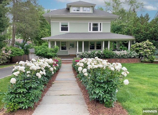 farmhouse with covered porch and a front lawn