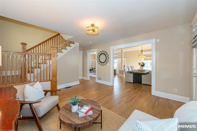 living room with a notable chandelier and hardwood / wood-style flooring