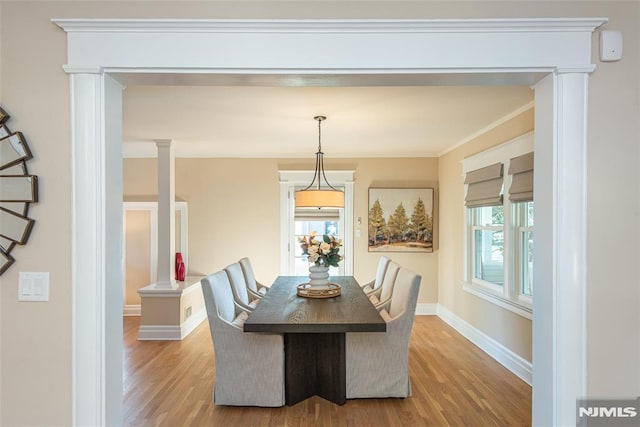 dining room with crown molding and light hardwood / wood-style flooring