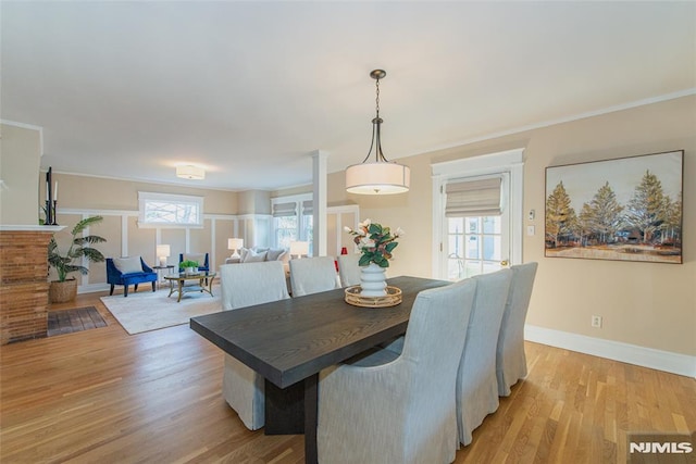 dining area featuring crown molding, a healthy amount of sunlight, and light wood-type flooring